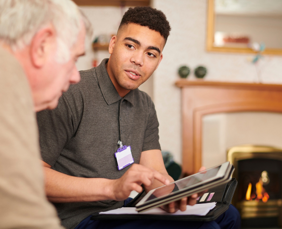 An occupational therapist showing a senior man an ipad